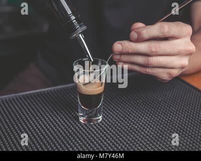 El barman prepara un B-52 en el bar de cócteles Foto de stock