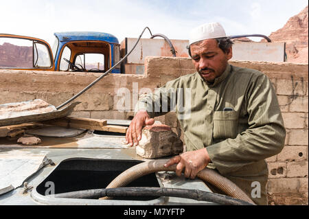 Hombre musulmán entregando agua por camión en la aldea de Wadi Rum en Jordania. Foto de stock