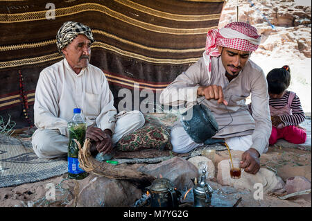 Dos Hombre bebiendo chai y relajándose en su tienda Beduina en Wadi Rum Jordania. Foto de stock