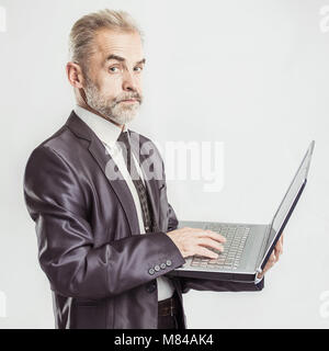 Retrato en pleno crecimiento - experimentado empresario con un portátil abierto sobre un fondo blanco. Foto de stock