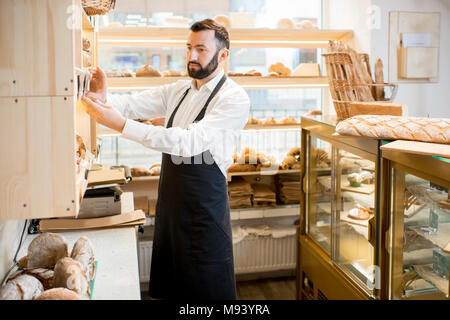 Vendedor trabaja en el almacén de pan Foto de stock