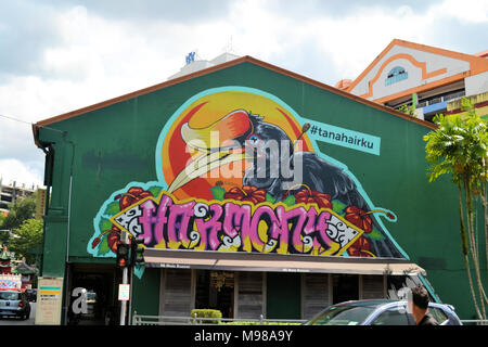Un graffiti de un amarillo grande facturó bocina-proyecto sobre un edificio de fabricación en Kuching Sarawak