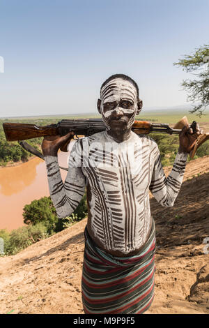 Guerrero con rifle Kalashnikov AK47, la tribu Karo, omo River, las naciones del Sur las Nacionalidades y los pueblos de la región, Etiopía Foto de stock