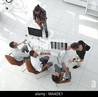 Ver la parte superior.Los empleados discuten ideas en su escritorio en la oficina Foto de stock