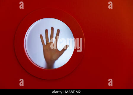 Ojo de buey roja redonda con mano femenina Foto de stock