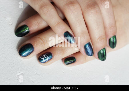 Las Manos De Una Nina Con Manicura Verde Que Muestra Una Senal De Peligro Biologico Biohazard Y Urraca Negra Pluma Vertical Fotografia De Stock Alamy