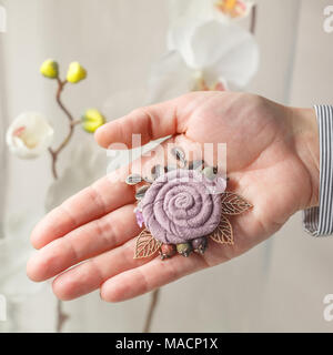 Broches hechos a mano en la forma de una gran flor de tela a cuadros y hojas de metal sobre fondo blanco Fotografía stock - Alamy