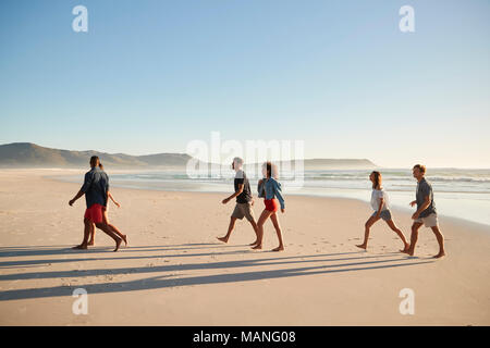 Grupo de Amigos de vacaciones junto a la playa caminando juntos Foto de stock