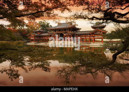 Rojo atardecer colorido paisaje de la Phoenix Hall, salón o Amida hoo-do de Byodoin templo budista en medio de la Tierra Pura Jodoshiki entei, estanque de jardín visible