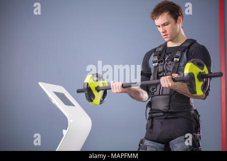 Hombre trabajando fuera la formación con EMS barbell closeup, poder plantear Foto de stock