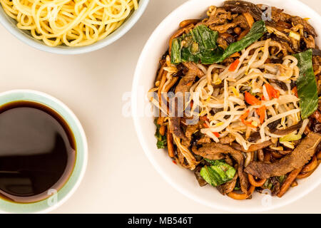 Estilo chino Wok de fideos fritos de carne de Shanghai contra un fondo gris Foto de stock