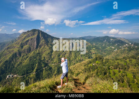Vertical horizontal de un turista tomando fotos de ella desde Little Rock Adam's Peak en ella, Sri Lanka. Foto de stock