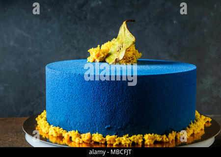 Pastel redondo azul decorado con pera secos y trozos de bizcocho amarillo  Fotografía de stock - Alamy