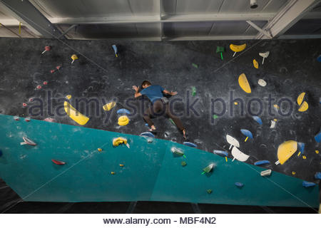 Macho maduro escalador muro de escalada en el gimnasio de escalada