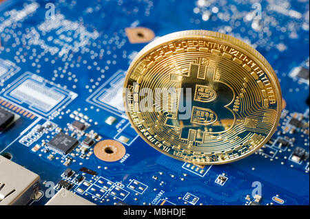 Bitcoin electrónica de pie en la placa base de un ordenador portátil Foto de stock