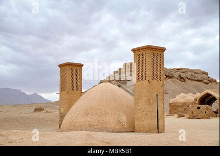 Las torres de viento utilizados como un sistema de refrigeración natural para el depósito de agua en la arquitectura tradicional iraní. Torre de silencio en el fondo. Yazd, Irán