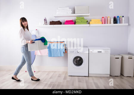 Mujer Joven Con La Cesta De Ropa En La Lavandería Imagen de