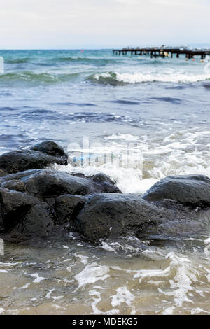 Las olas del mar línea de pestañas de impacto en la playa de roca Foto de stock