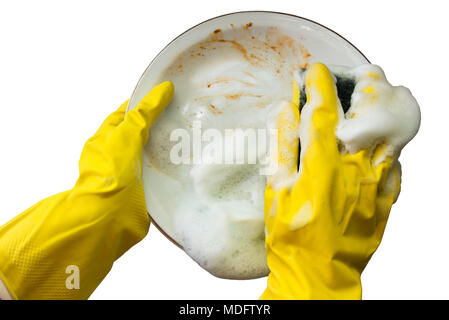 Un par de manos con guantes amarillos lavar un plato sucio Foto de stock