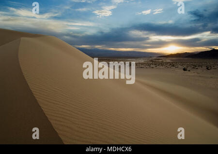La arista curvada de arena que revela la luz y el lado oscuro de una duna en Ibex Dunes, California. Foto de stock