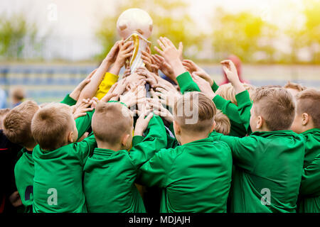 Los niños celebrando la victoria de fútbol. Los jóvenes jugadores de fútbol Celebración del trofeo. Los niños celebrando el campeonato deportivo. Equipo ganador del torneo deportivo para niños