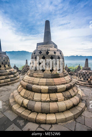 Las estupas perforadas que contienen estatuas de Buda en el top terrazas circulares del siglo ix templo Budista Borobudur, en Java Central, Indonesia Foto de stock