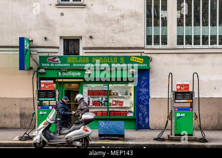 Un operador de bomba de gasolina refuels una motocicleta en una estación de gasolina en el Boulevard de Clichy, Pigalle, Montmartre, Paris Foto de stock