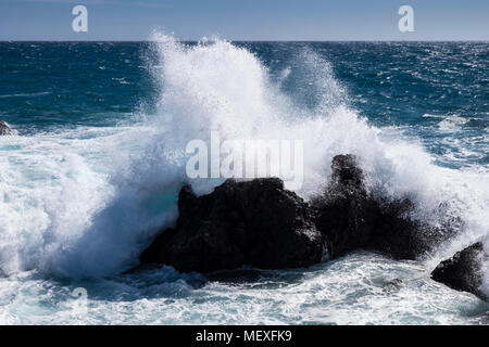 El mar embravecido rompiendo sobre las rocas a lo largo de la costa oeste de Tenerife en Playa San Juan, Islas Canarias, España Foto de stock