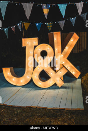 Letras de madera artesanales iluminado con lámparas de luz en una noche de fiesta de campo