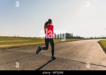 mujer corriendo en un camino de campo a través del hermoso bosque soleado,  el ejercicio y el concepto de fitness Fotografía de stock - Alamy