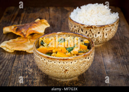 Plato de curry con coliflor, calabacita calabaza, espinaca y cilantro, papadam y arroz Foto de stock