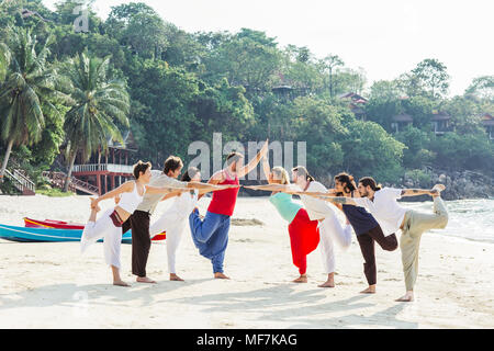 Tailandia, Koh Phangan, grupo de personas haciendo yoga en la playa
