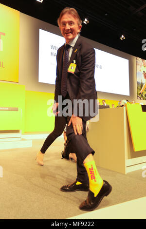 Bonn, Alemania, el 24 de abril de 2018, Deutsche Post DHL reunión general anual: miembro del comité ejecutivo Allen lleva calcetines de color amarillo con el logotipo de DHL. Crédito: Juergen Schwarz/Alamy Live News Fotografía de stock -