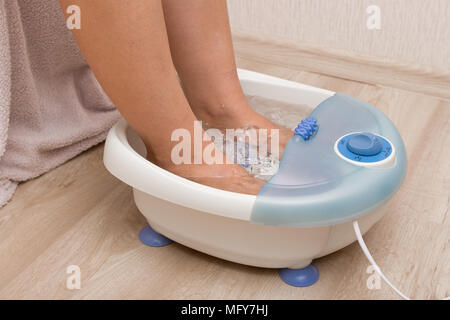 Pies en un vibrador masajeador de pie. Bañera de masaje eléctrico.  Pediluvio antes una pedicura Fotografía de stock - Alamy