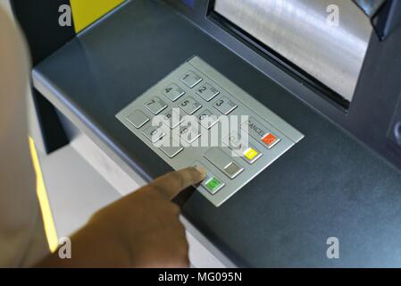 Persona con ATM. Imagen de la mano de persona pulsando los botones numéricos para introducir el código pin para cajeros automáticos de banco. Concepto de seguridad financiera, el robo, el fraude bancario