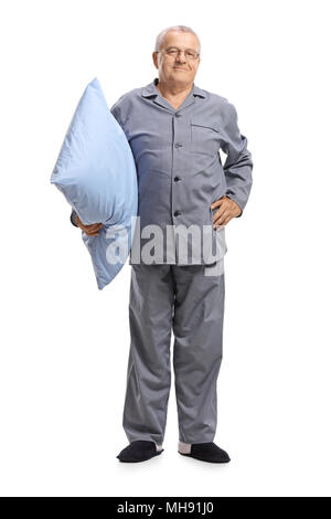Longitud total retrato de un hombre maduro en pijama sosteniendo una almohada aislado sobre fondo blanco.