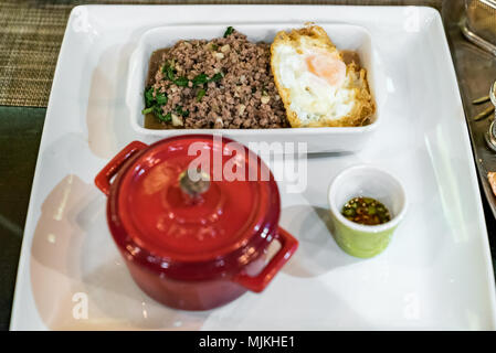 Mezcle la carne frita con albahaca y arroz cocido y huevo frito Foto de stock