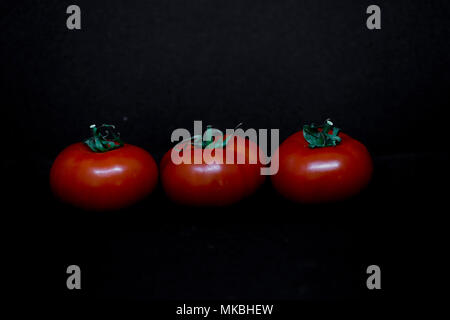 Tomates frescos sobre fondo negro. Conceptos alimentarios. Ilustrativo