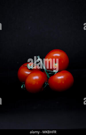 Tomates frescos sobre fondo negro. Conceptos alimentarios. Ilustrativo