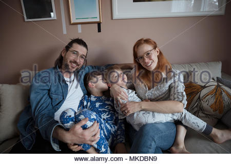 Retrato sonriente, feliz familia en el sofá de la sala