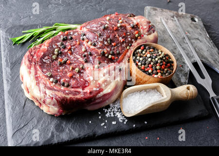 Veteado chuletón steak en placa negra Foto de stock