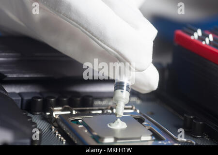 Técnico de aplicar pasta térmica con jeringa en el procesador de la CPU en  la placa base portátil Fotografía de stock - Alamy