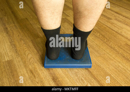 Piernas de hombre en calcetines negros se levantan en una balanza