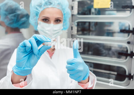 Técnico de laboratorio o científico con plato delante de la estufa Foto de stock