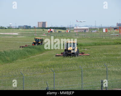 Cortar la hierba en el campo operacional en el DFW International Foto de stock