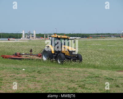 Cortar la hierba en el campo operacional en el DFW International Foto de stock