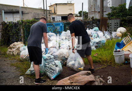 Dos marines estadounidenses con Marina escuadrón de helicópteros pesados  lugar 462 bolsas de basura de plástico en la basura mucho en Nakagusuku  Playa, Okinawa, Japón, 14 de octubre de 2017. El 'pesado'
