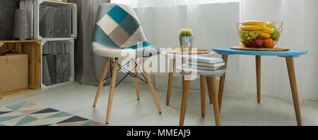 Cerca de una mesa de café y un mosaico silla en una luminosa sala de estar moderna