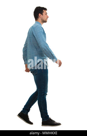 Perfil de longitud completa la foto de un joven hombre que confía caminando aislado sobre fondo blanco. Foto de stock