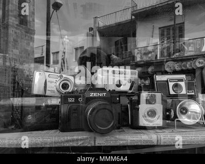 Nicosia, Chipre - Abril 26, 2018: Un surtido de vintage clásico film cámaras y unidades flash aparece en una ventana de la tienda de antigüedades Foto de stock